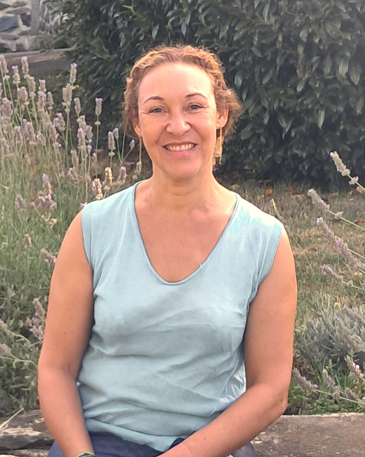 Marjolaine Sami souriante, assise dans un jardin de lavande